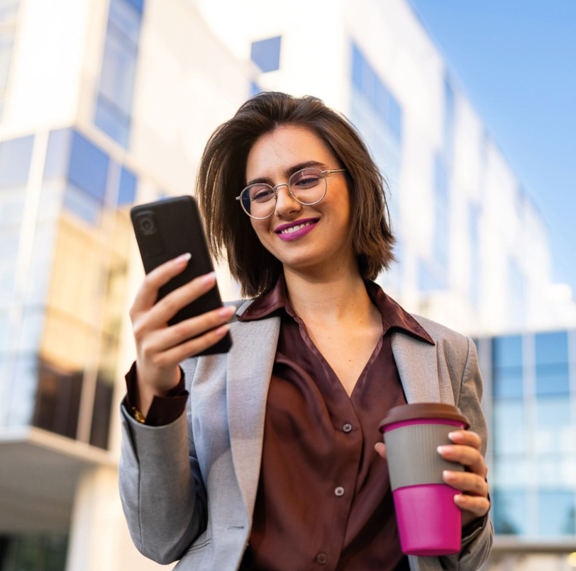 Woman holding a coffee cup and a mobile
