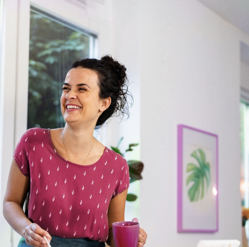 Woman in kitchen holding mug